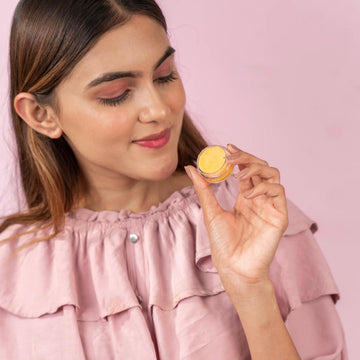 A girl holding lemon lip balm pack